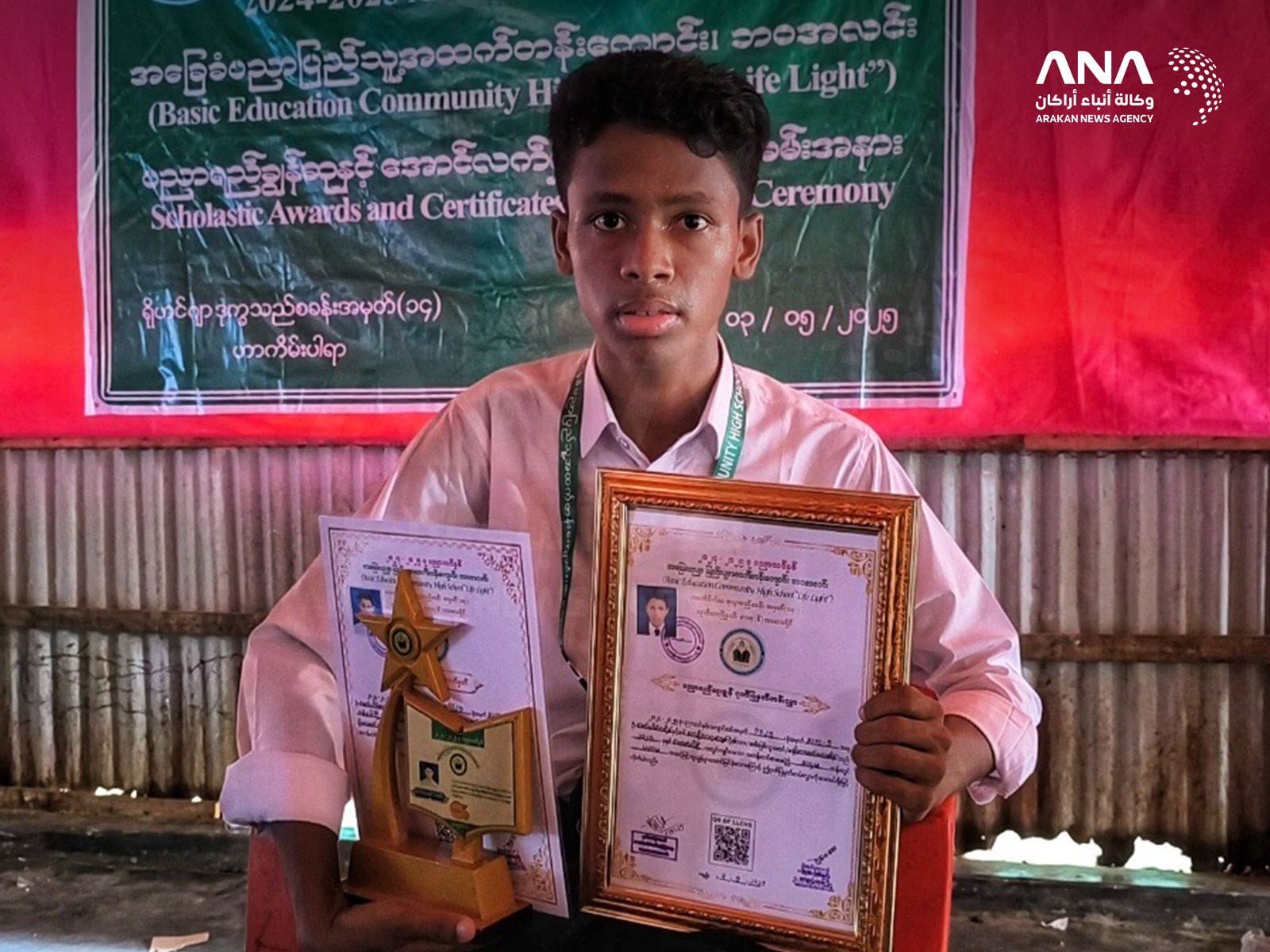 Rohingya student Mohamed Yasin holding awards he earned (Image: ANA)